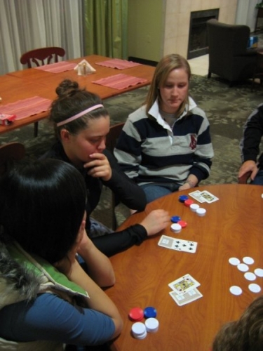 Katie is planning out her next move during an intense game of poker with the Hope Lodge residents.